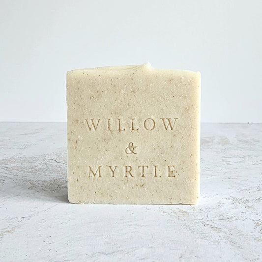 creamy pale beige coloured soap bar with specks, willow & myrtle logo stamped in front. square shape with white background and marbled surface
