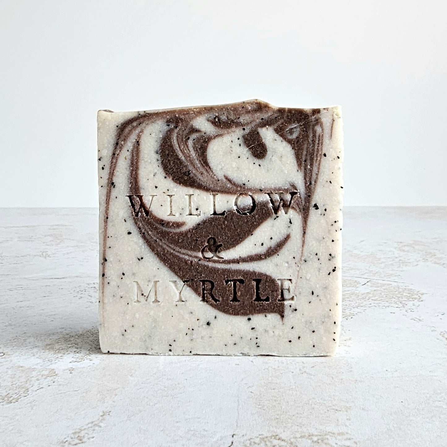 beige soap with cocoa swirled through. specs of ground coffee.