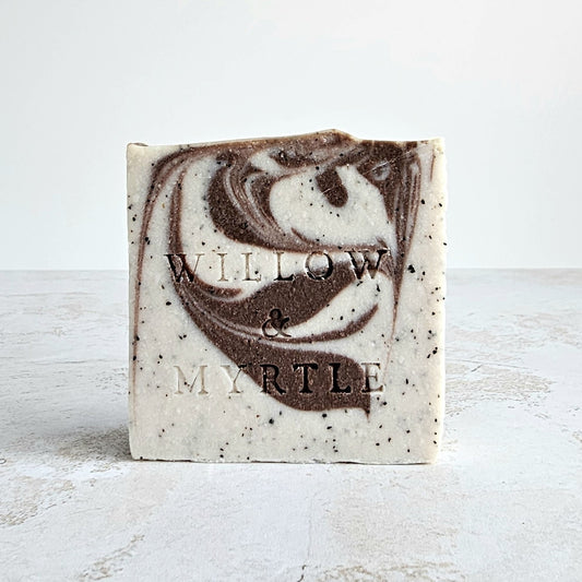 beige soap with cocoa swirled through. specs of ground coffee.