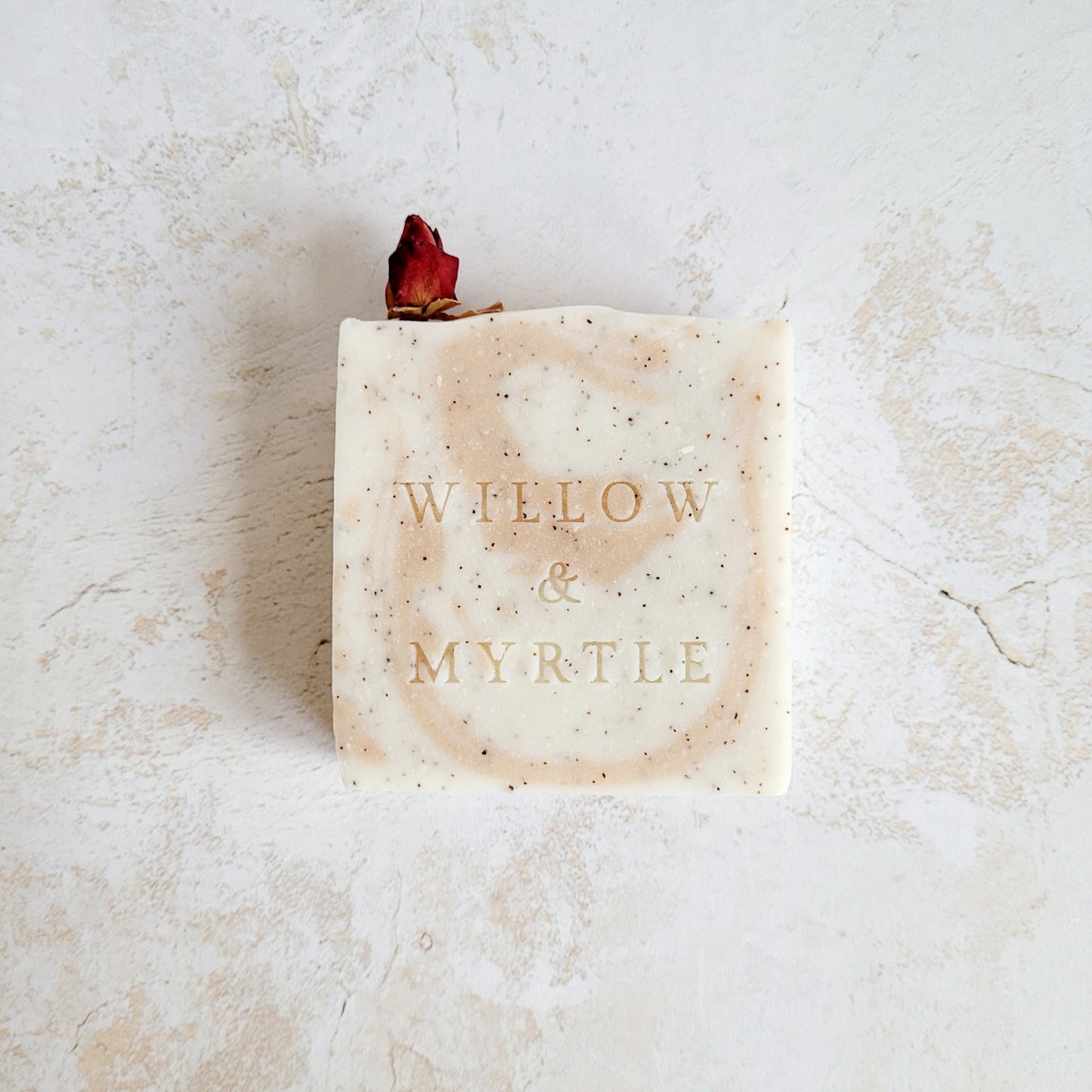 rose clay swirl and specks of ground apricot stone for exfoliation. dried rose bud for decoration