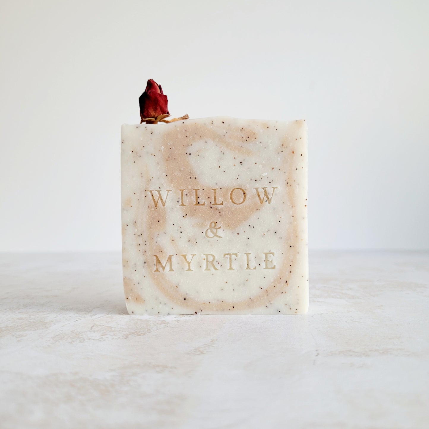 Wild rose soap. rose clay swirl and specks of ground arpicot stone for exfoliation. dried whole rose on top for decoration.