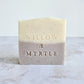lavender soap, layered design with purple bottom and beige top. square soap with specs of oatmeal