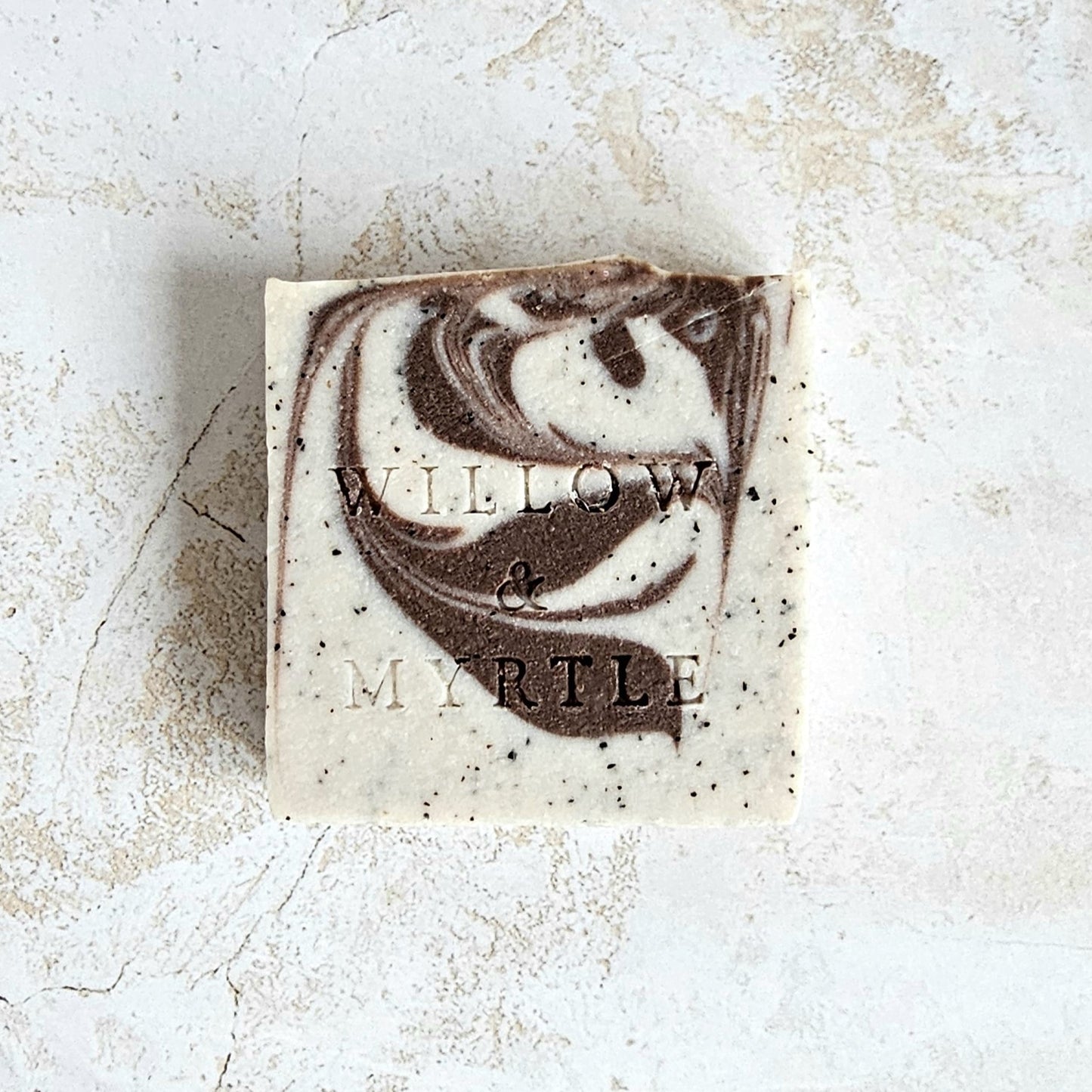 square soap with cocoa swirl and specs of coffee. willow & myrtle logo stamped in front