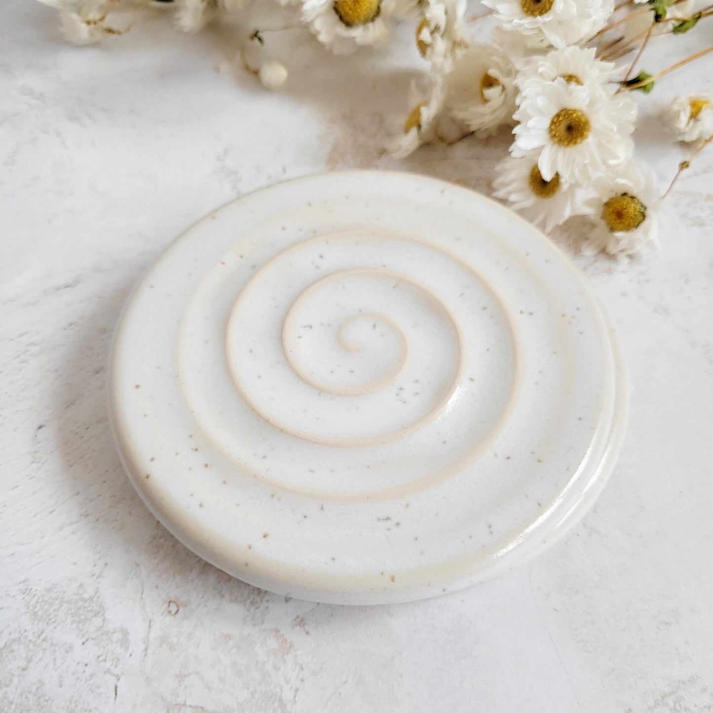 white speckled ceramic soap dish with groves for drainage